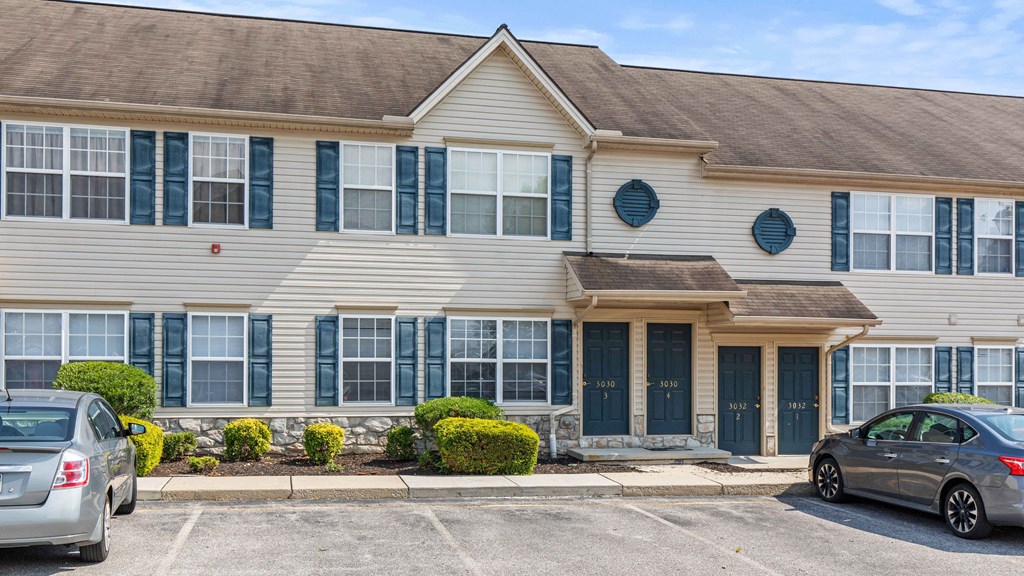 a large white house with cars parked in front of it