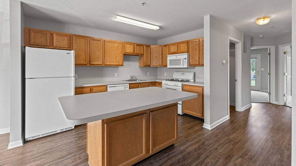 a kitchen with wooden cabinets and a white counter top