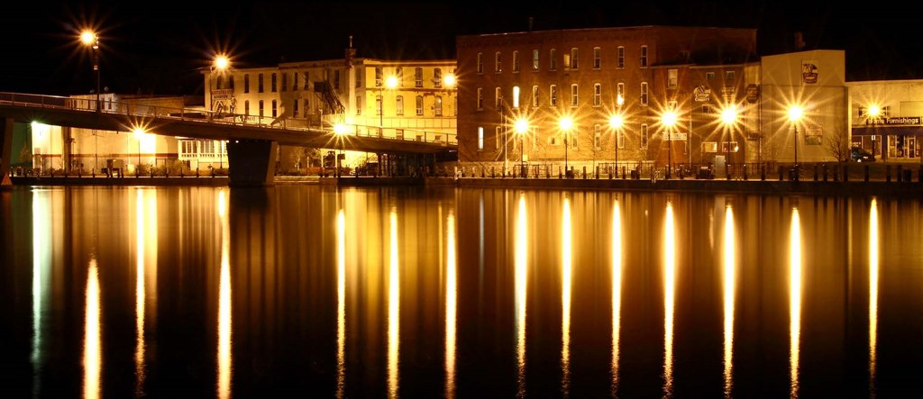 a city at night with its lights reflected in the water