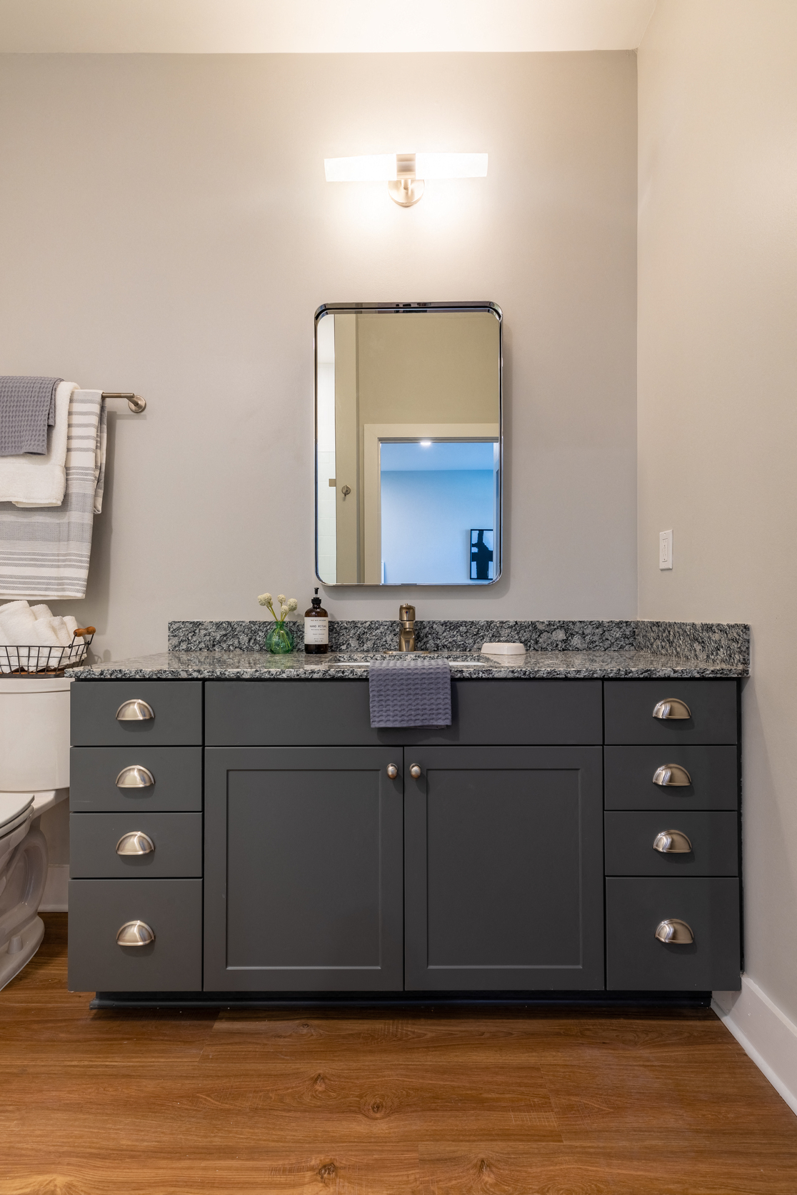 a bathroom with a black vanity and a mirror