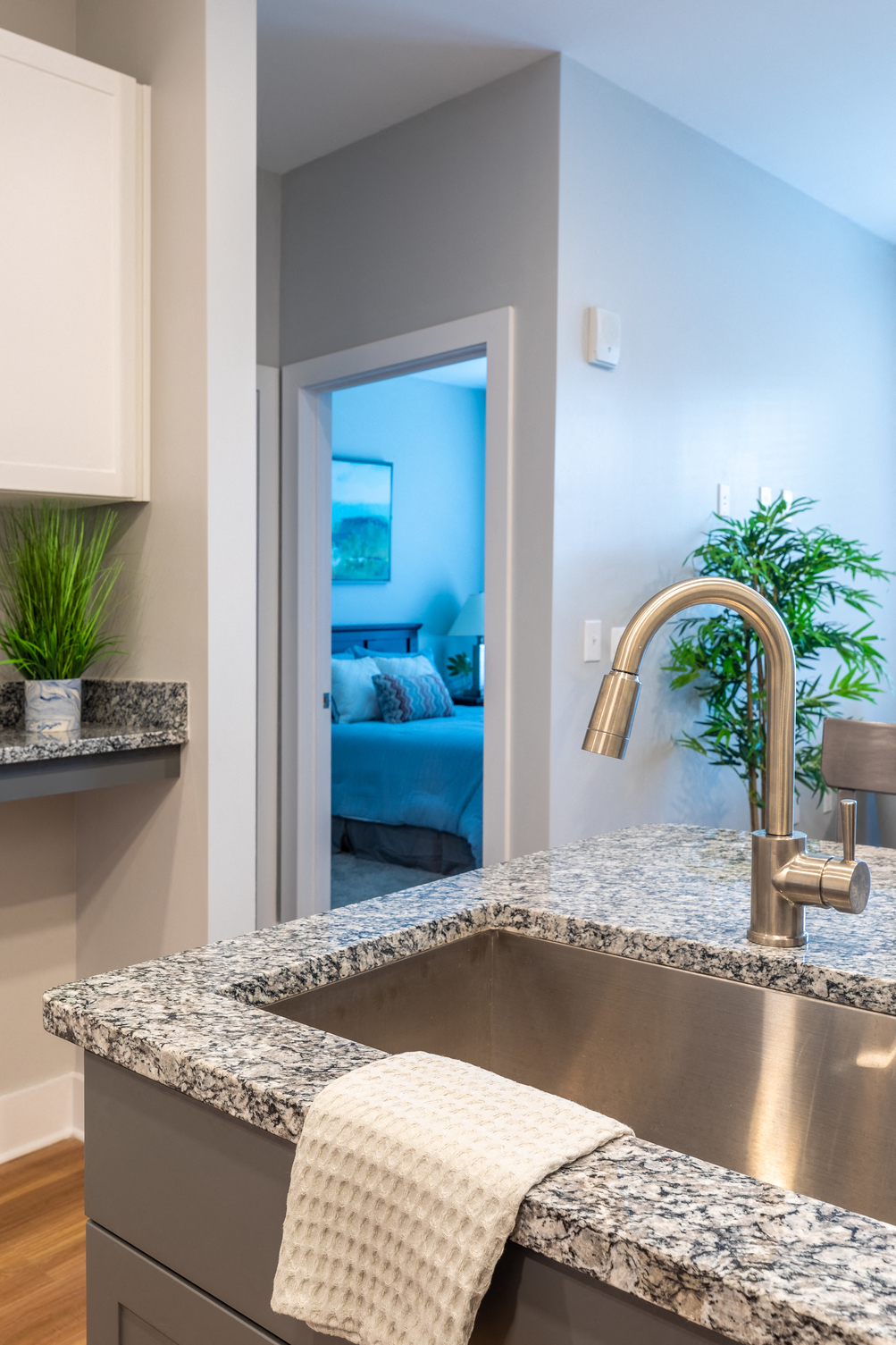 a kitchen counter with a sink and a door to a bedroom