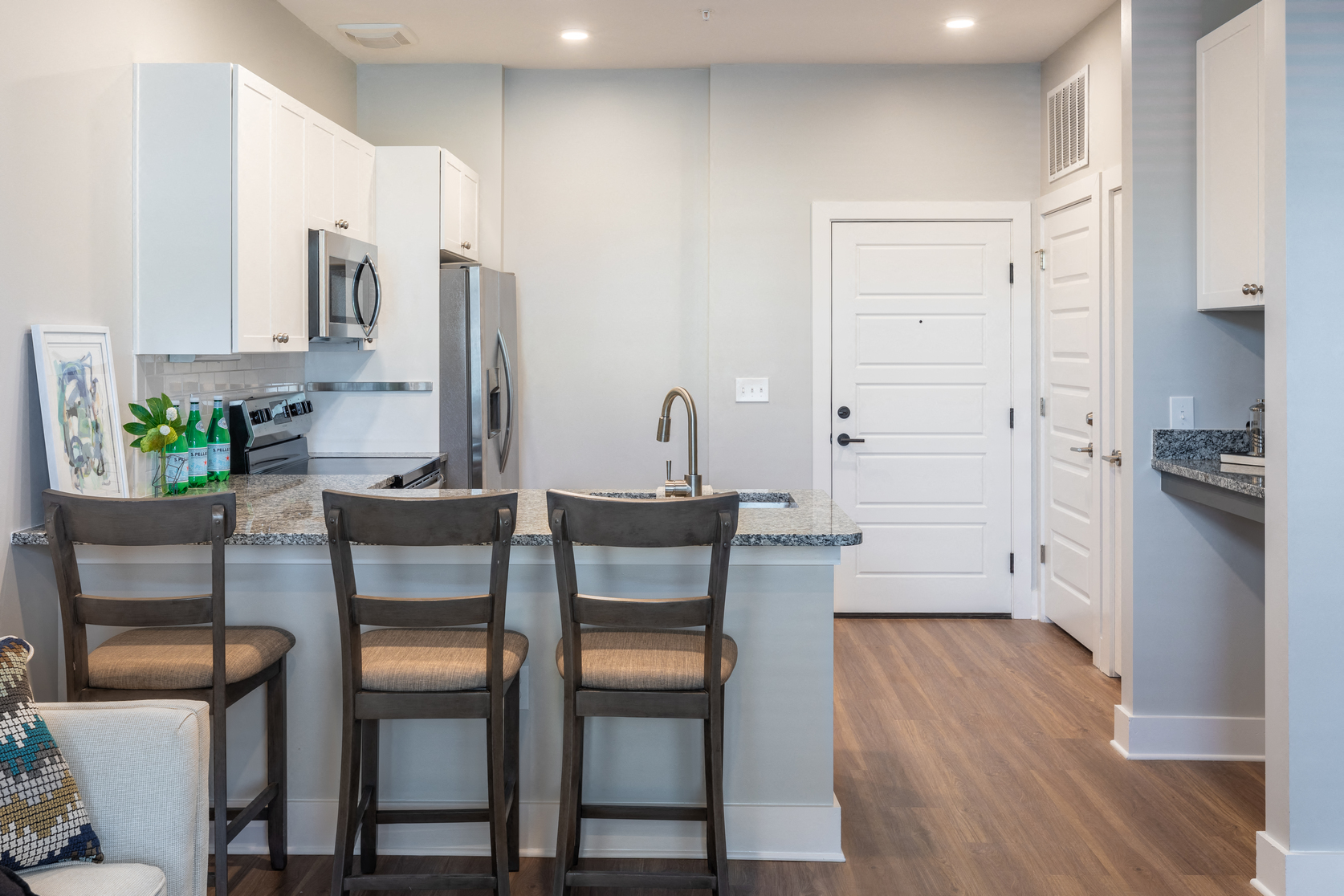 a kitchen with a counter with two chairs in front of a counter top