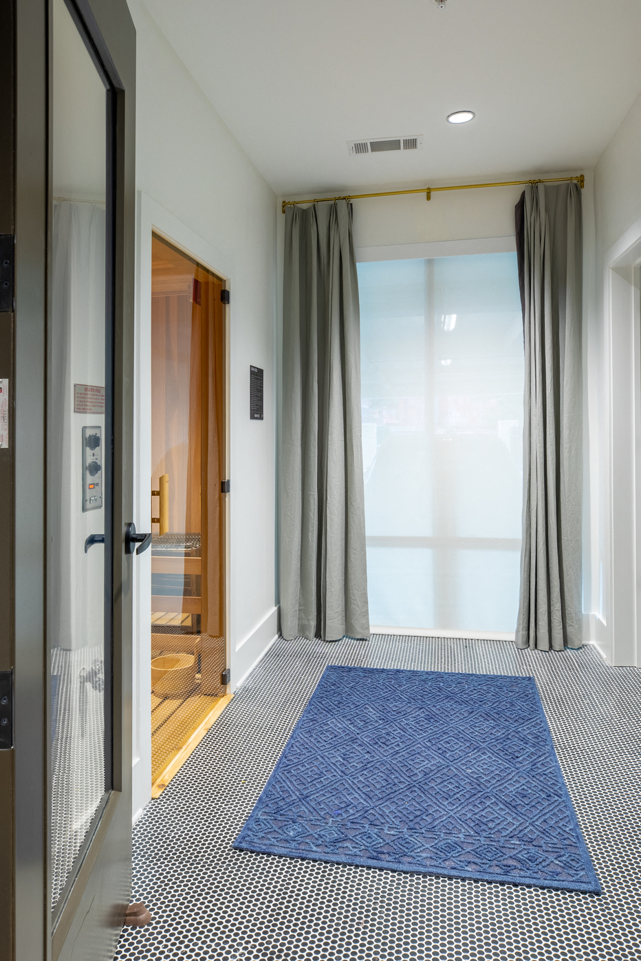 a blue rug in a room with a door and a window