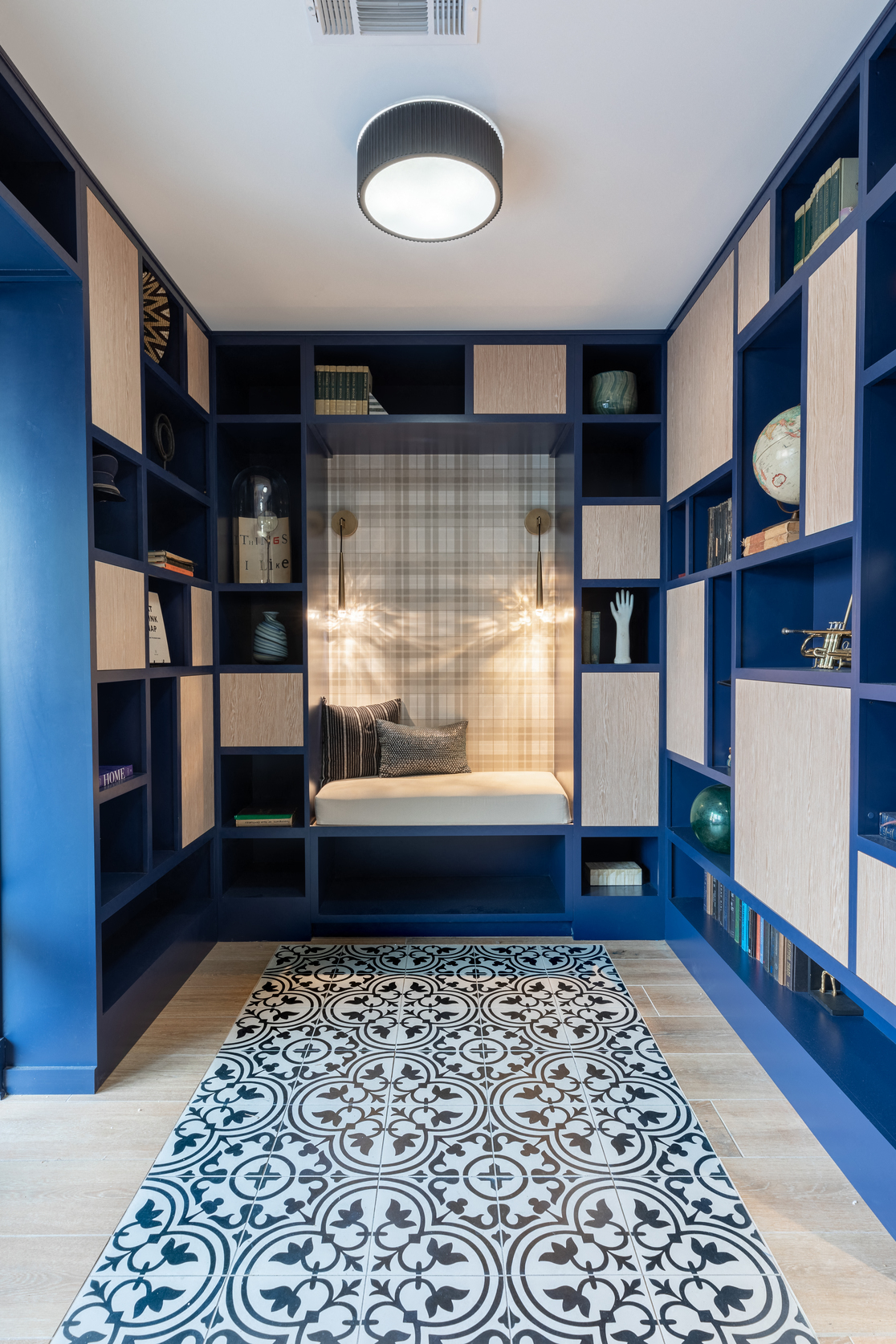 a blue room with blue shelving and a blue and white rug