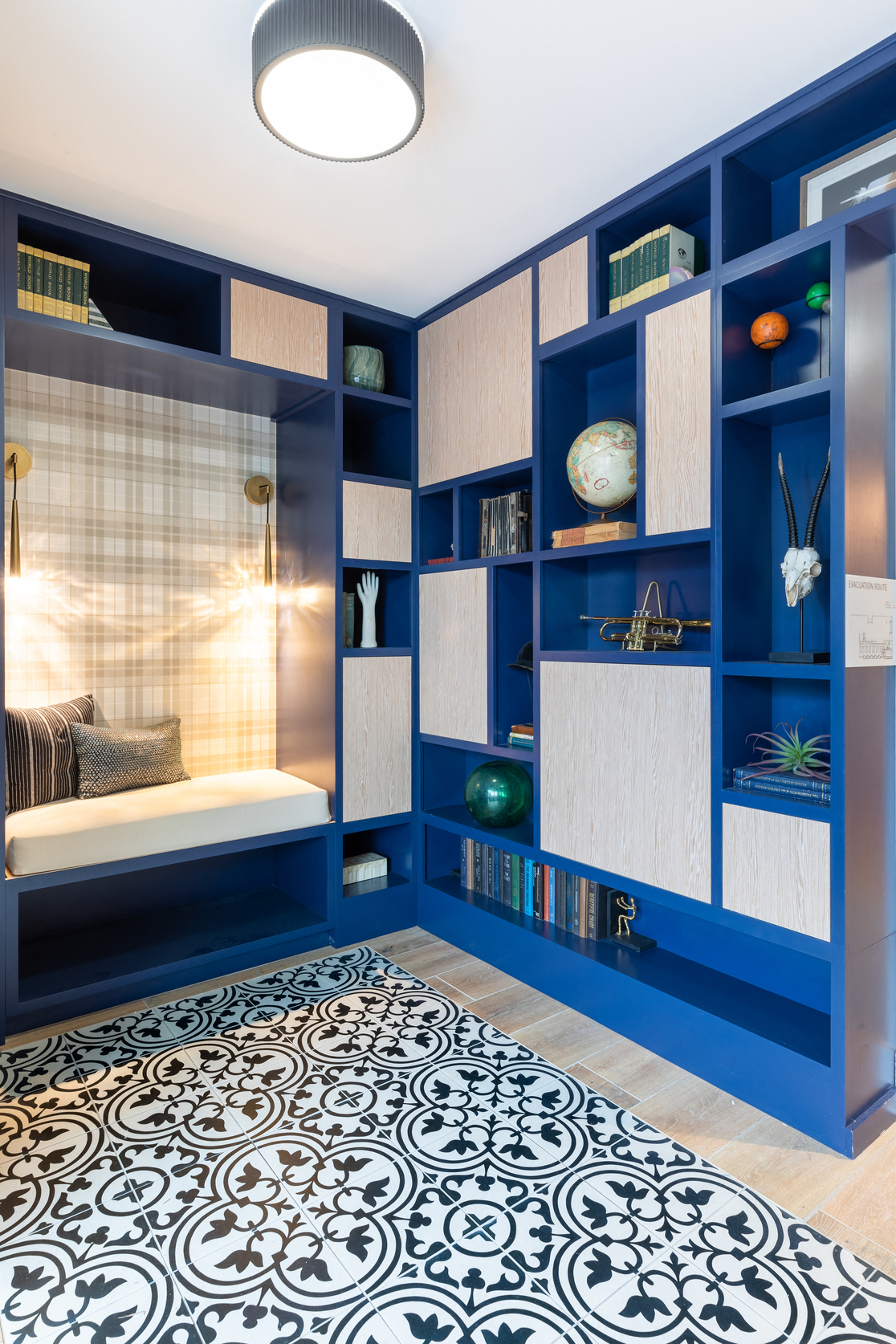 a blue and white bedroom with blue shelving and a bed