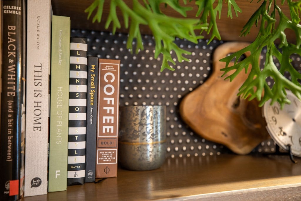 a book shelf with books and a vase with a plant