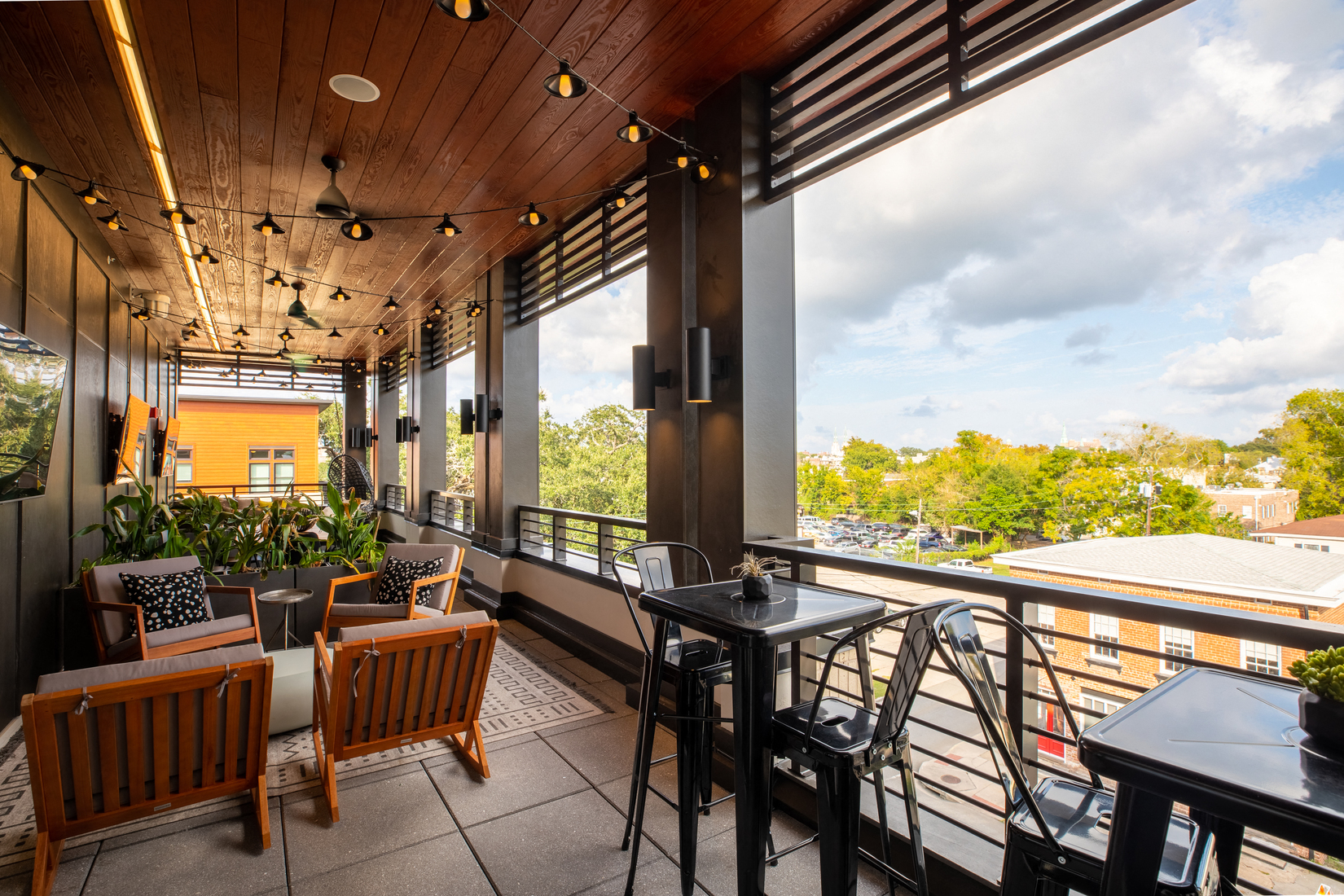 a patio with tables and chairs and large windows