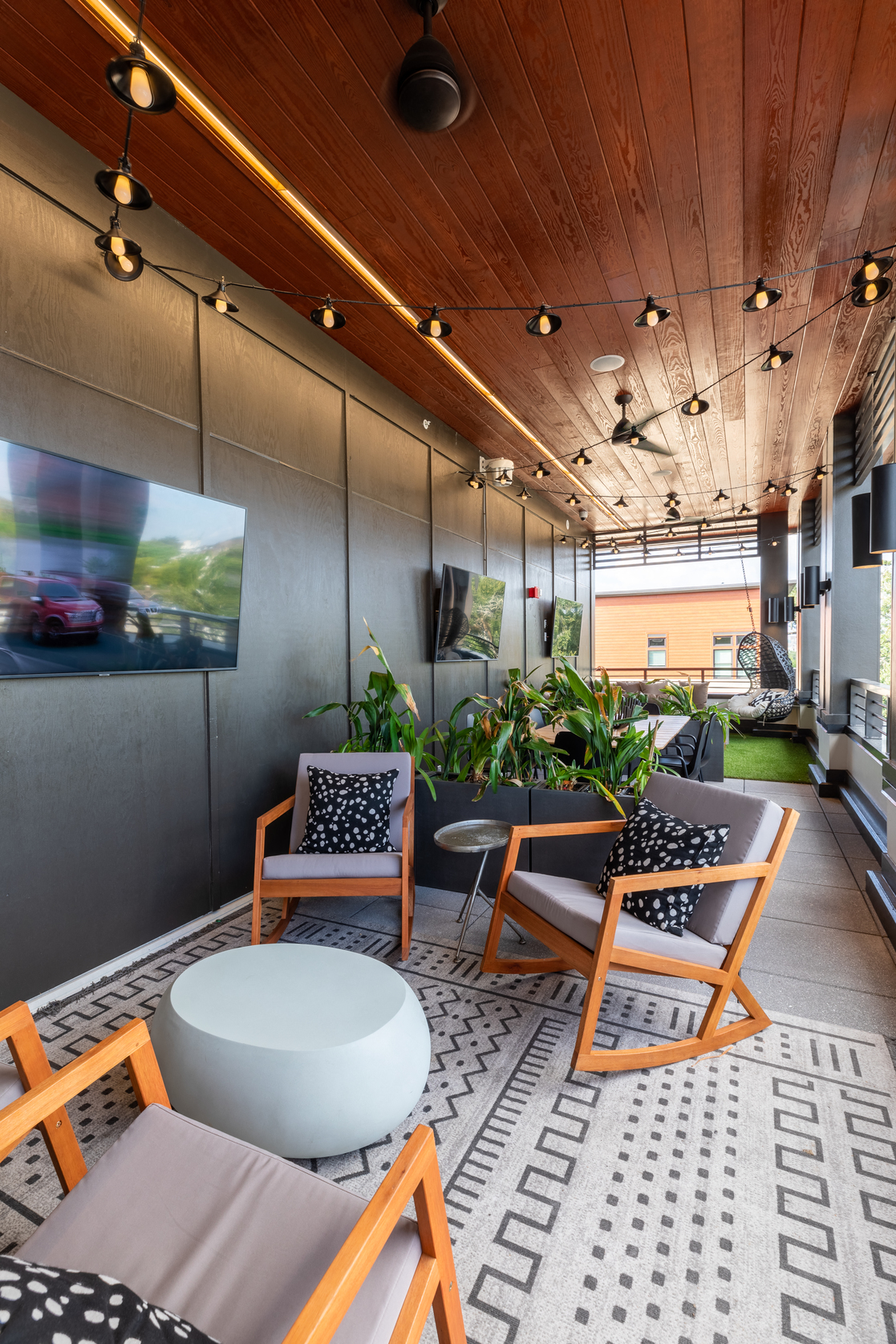a lounge area with chairs and tables and a television