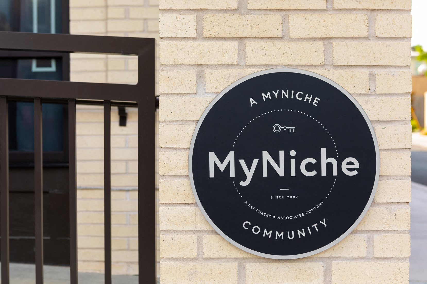 a black sign on a brick wall saying community