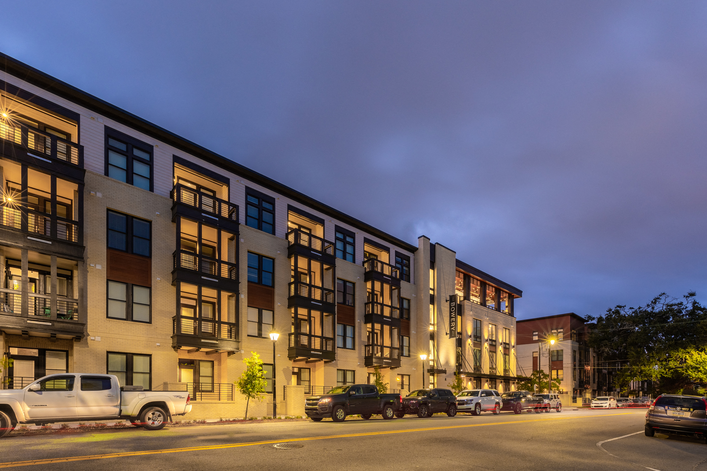 a row of apartment buildings on a city street at night