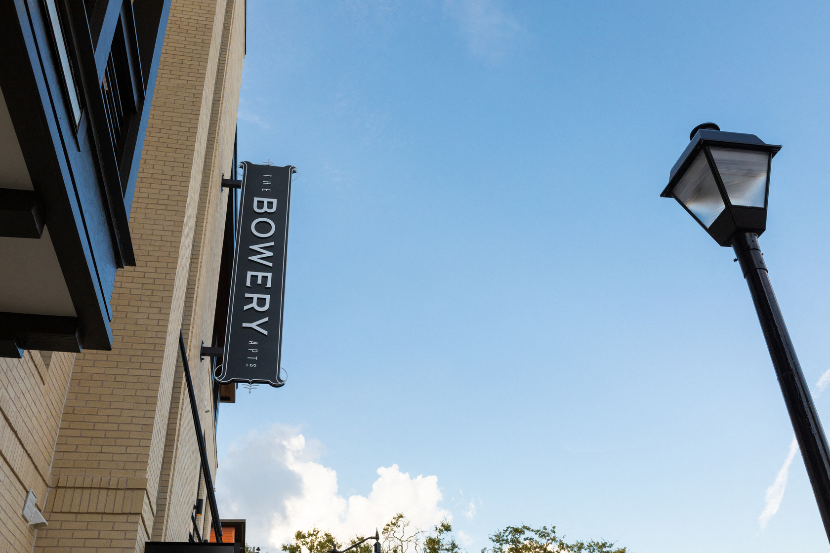 a sign on the side of a building with a street light
