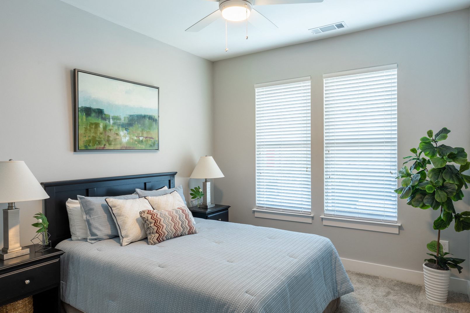 a bedroom with a large bed and two windows