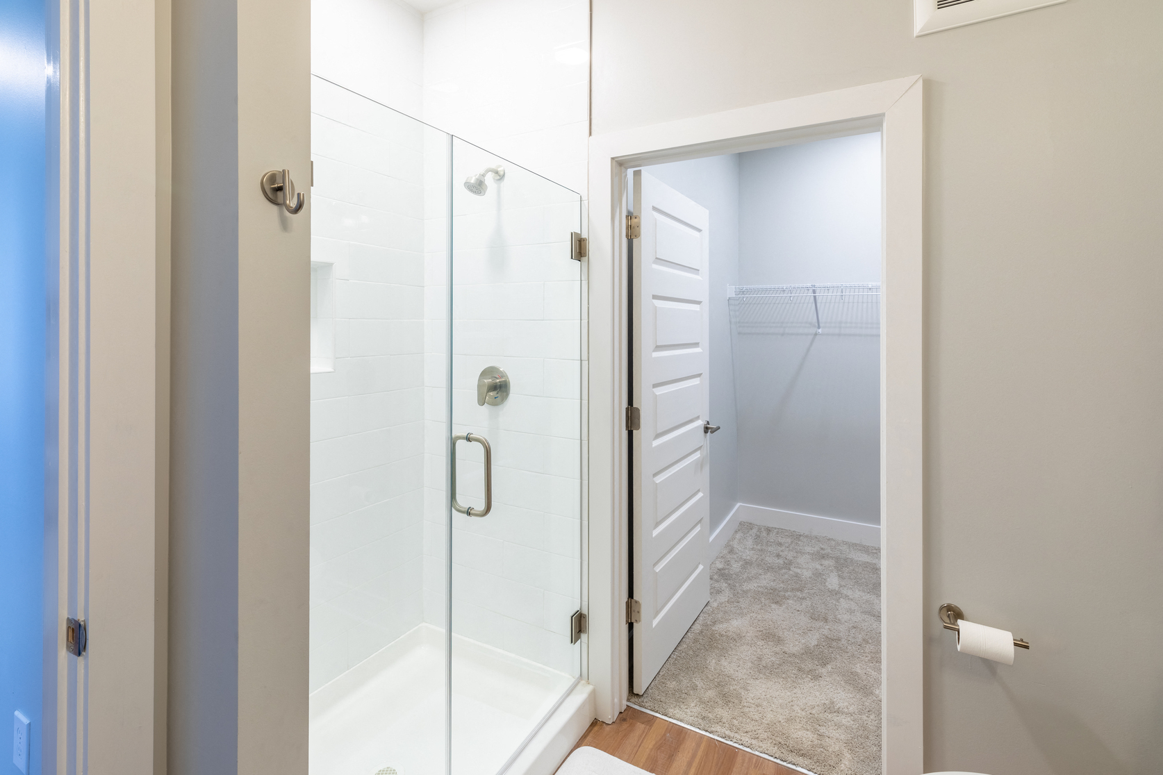 a bathroom with a shower and a door to a closet
