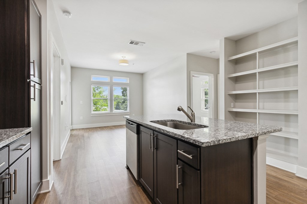 an empty kitchen with a sink and a counter top