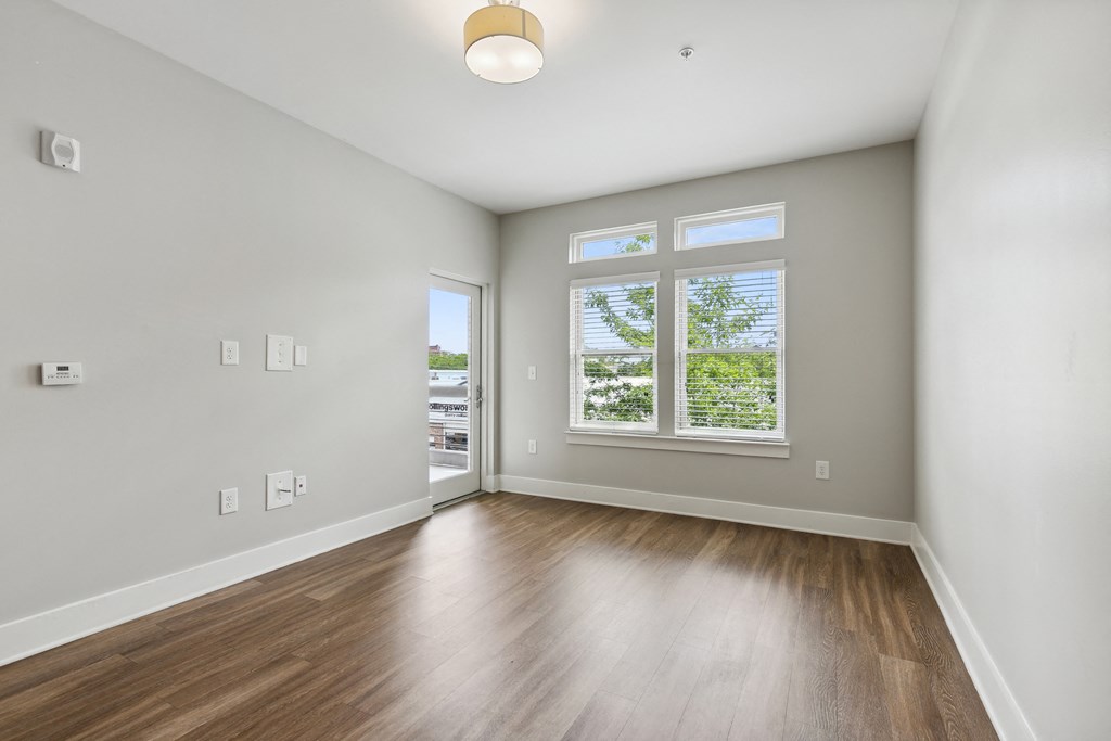 an empty living room with hardwood floors and a window