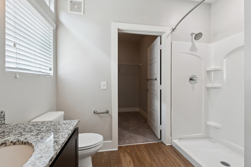 a bathroom with a shower and a toilet and a sink