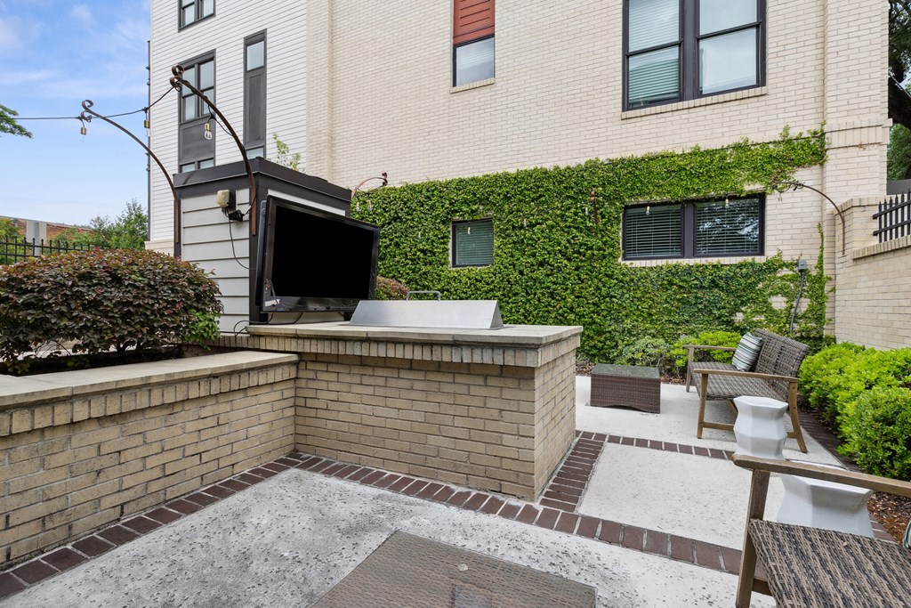 a backyard with a tv and a patio with a table and chairs