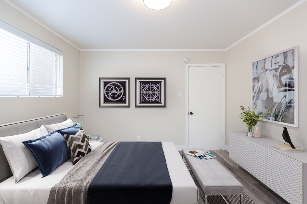 a bedroom with a bed and two pictures on the wall