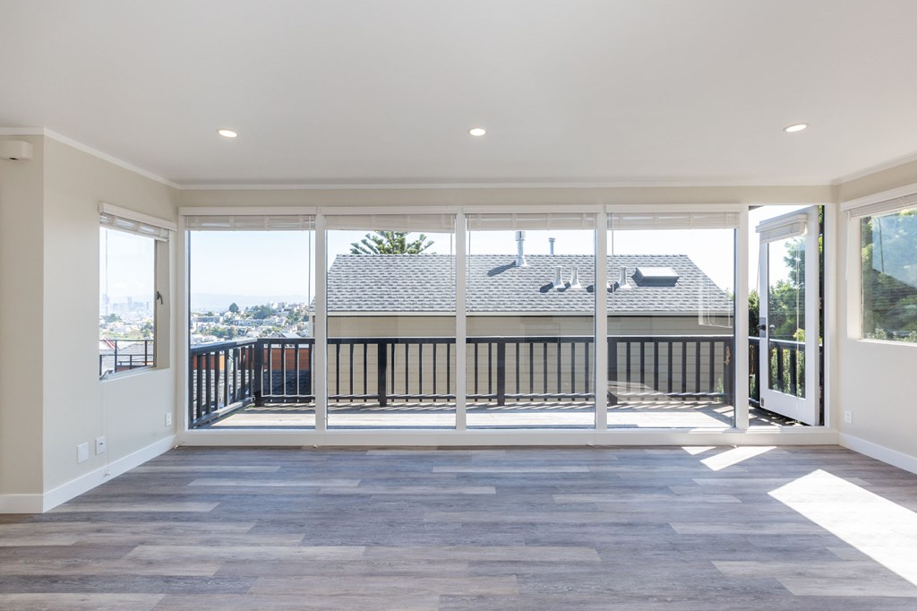 a living room with large windows and a balcony