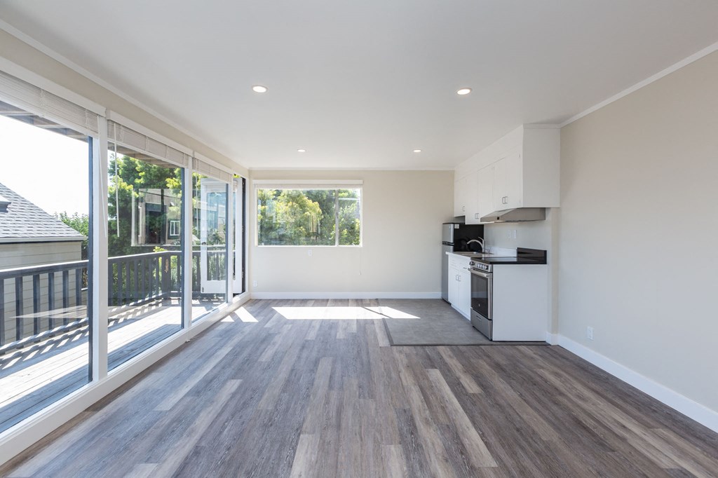 a living room with a kitchen and a balcony