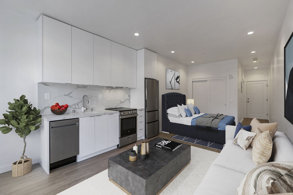 A modern living room with a kitchen area in the background.