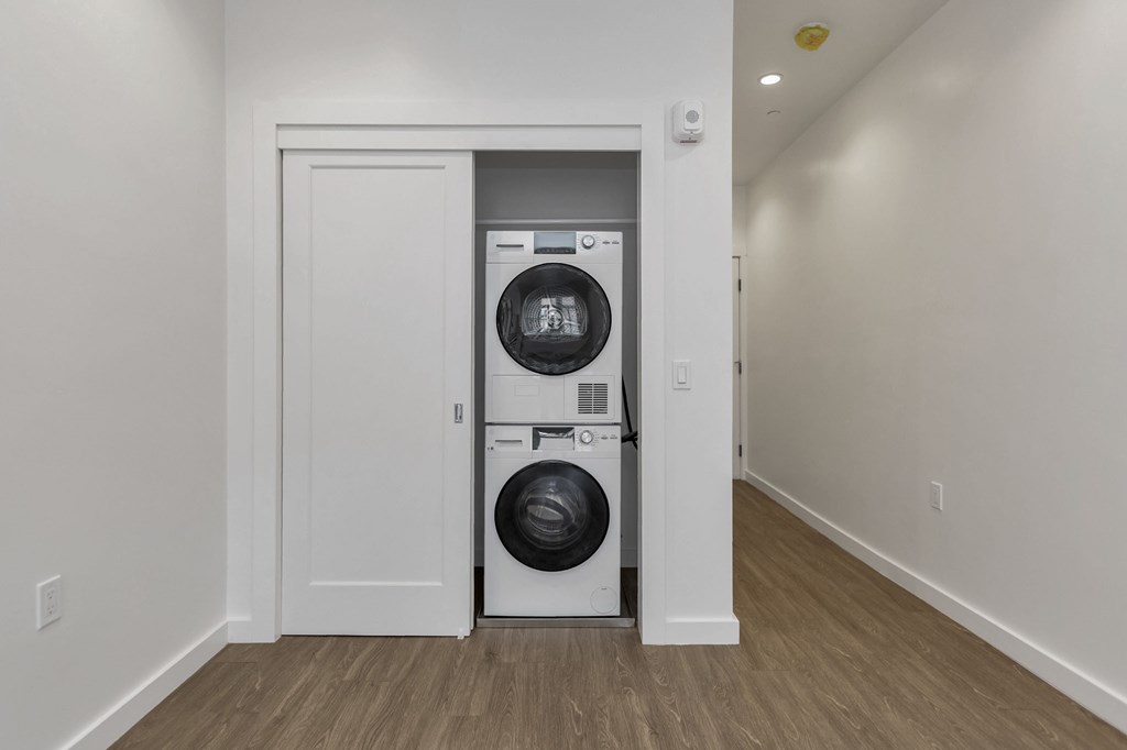 A white door is open to a small laundry room with a washer and dryer.