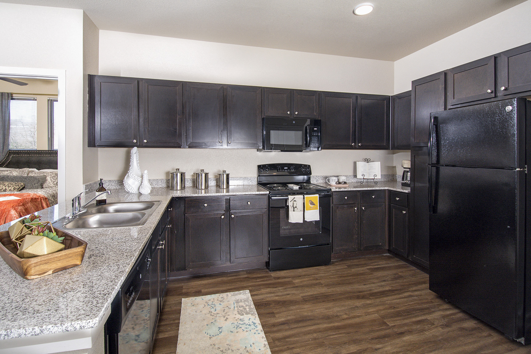 A kitchen with black cabinets and a black refrigerator.