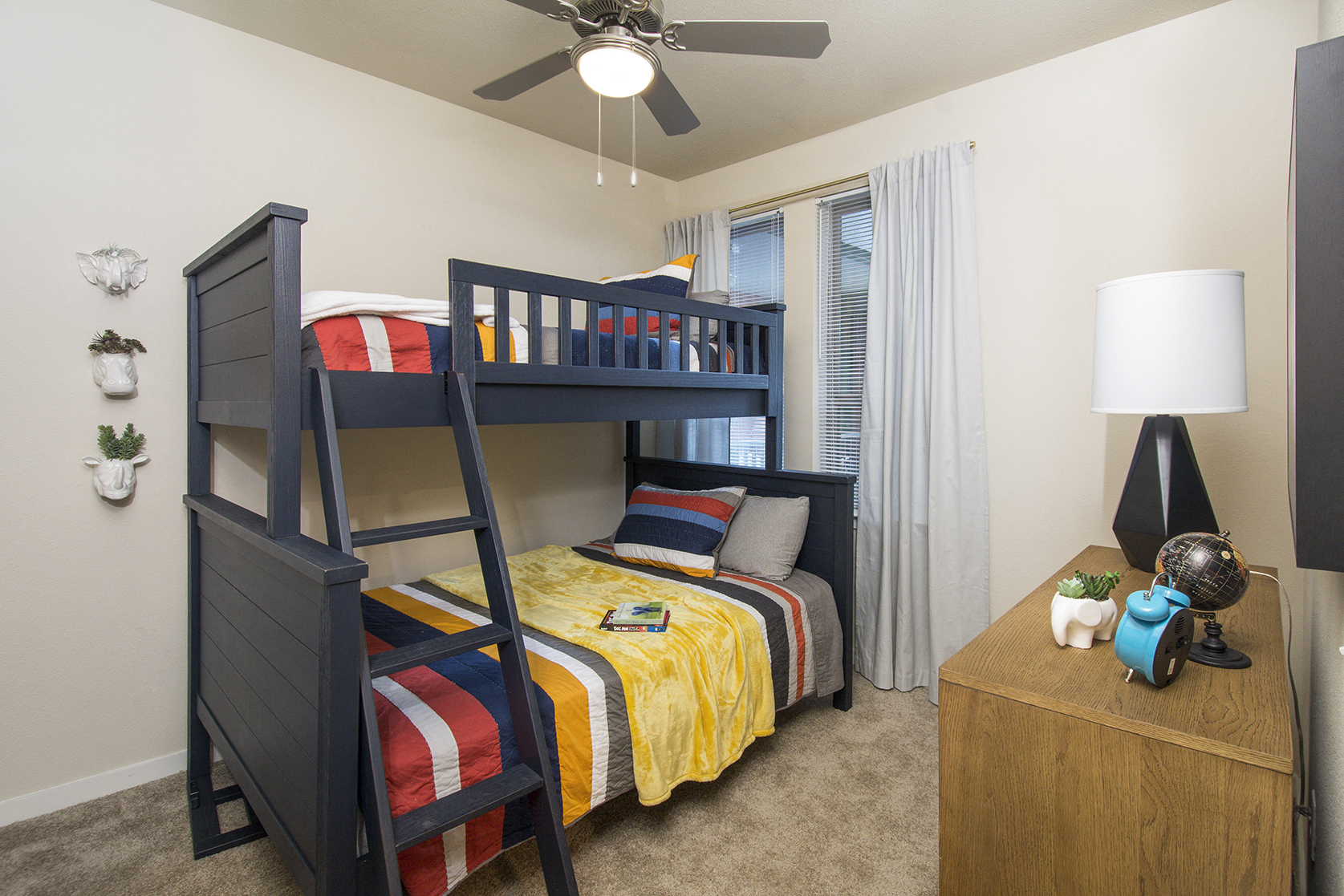 A bedroom with a bunk bed and a ceiling fan.