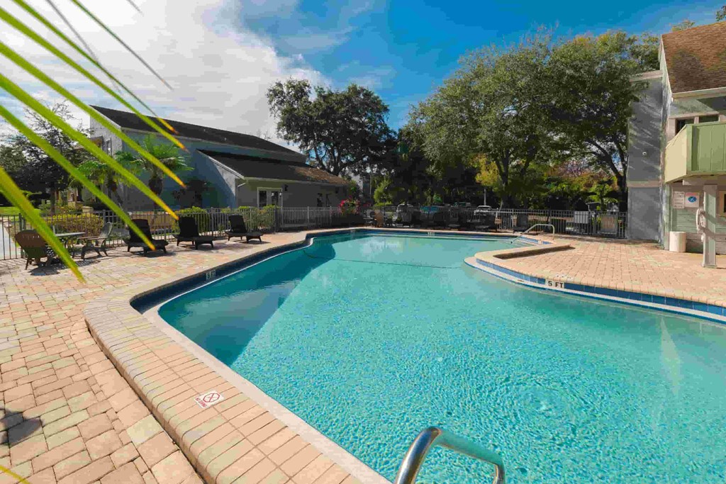 a swimming pool at a resort with a building in the background