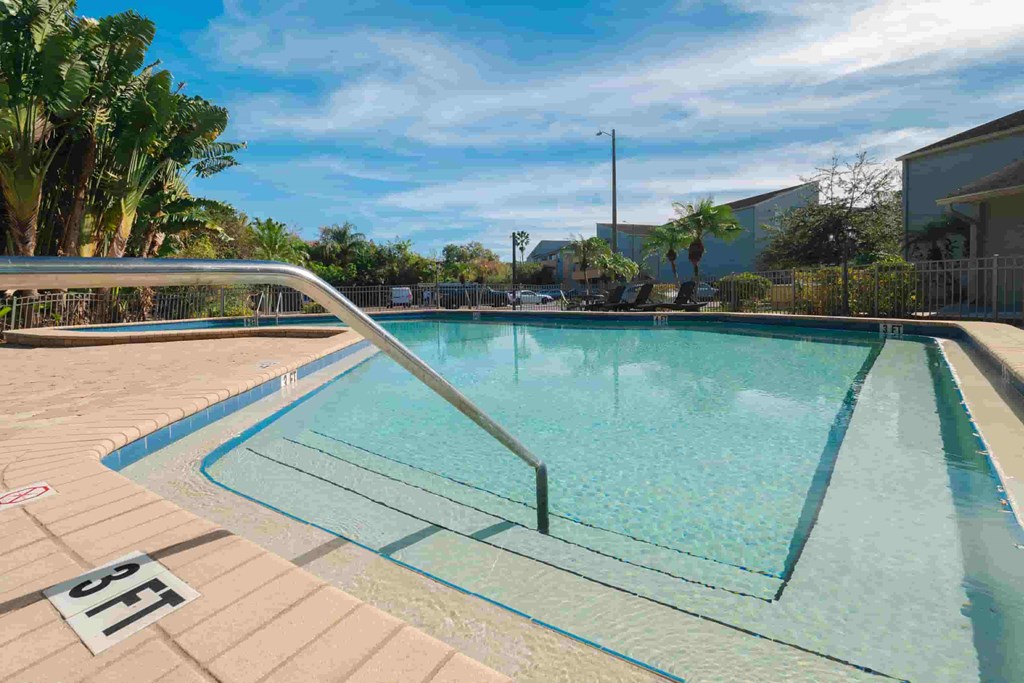 a resort style pool with a stainless steel fence around it