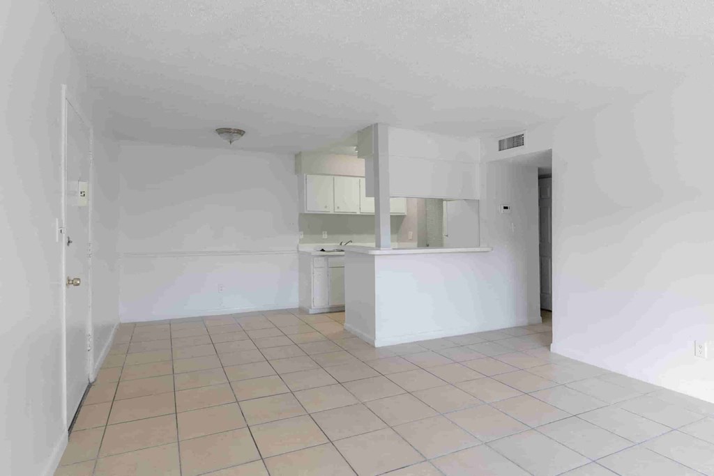 an empty kitchen with white walls and a tile floor