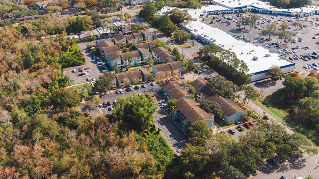 an aerial view of a neighborhood with cars parked in a parking lot