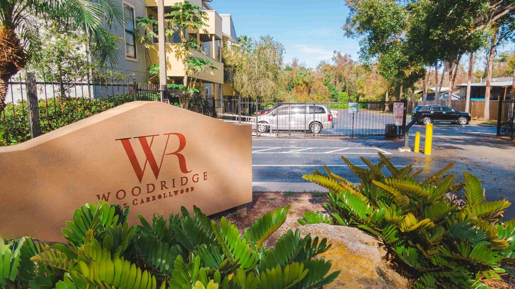 a sign for woodridge apartments in front of a parking lot