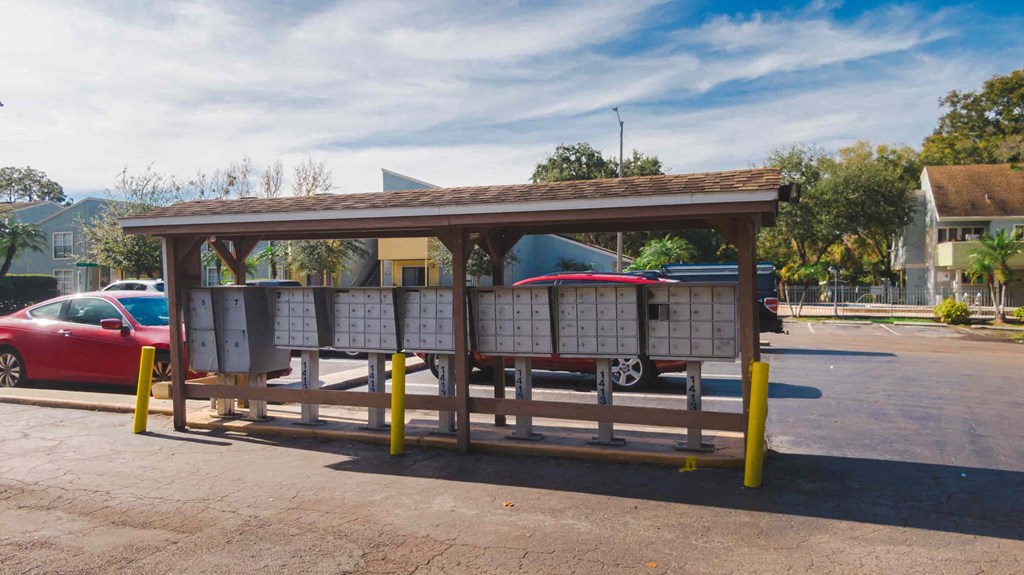 a bus stop with a red car parked next to it
