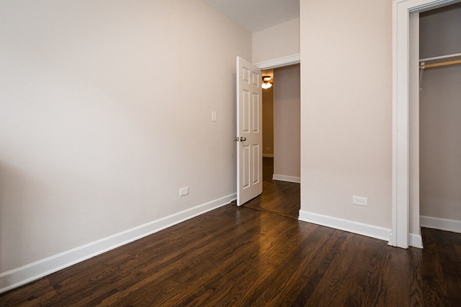 a living room with wood floors and a door to a hallway
