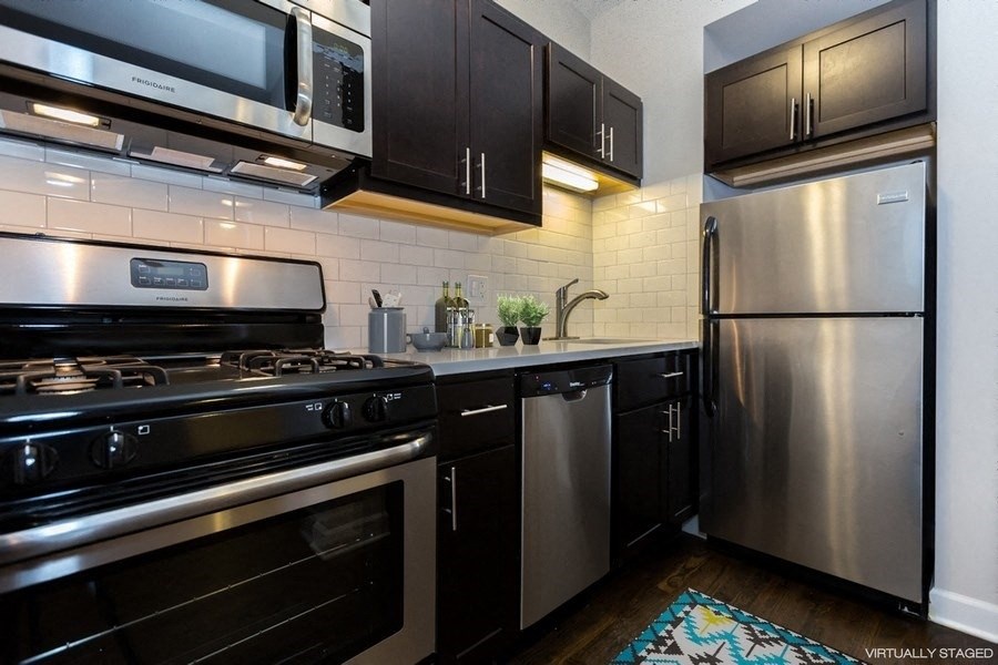a kitchen with stainless steel appliances and black cabinets