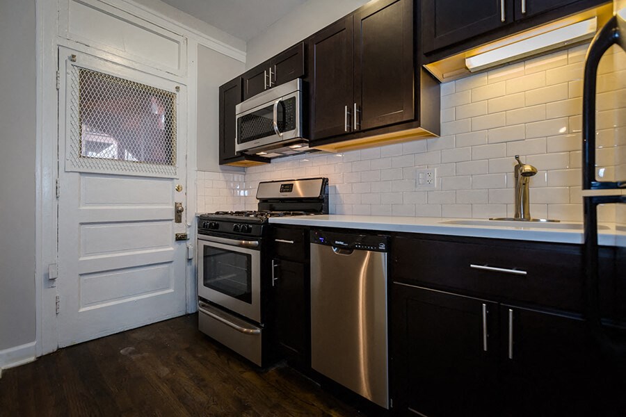 a kitchen with stainless steel appliances and black cabinets