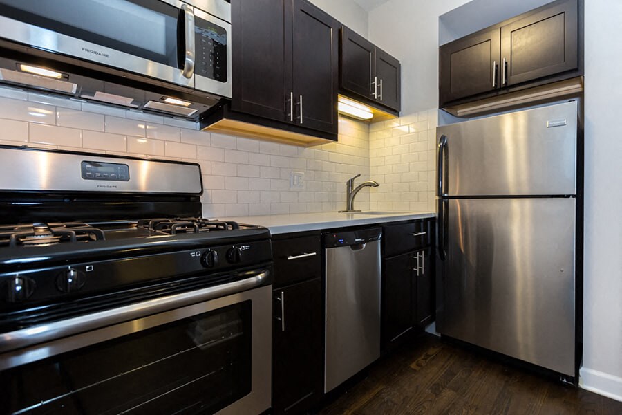 a kitchen with stainless steel appliances and black cabinets