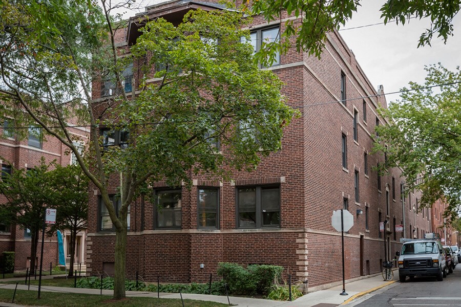 a red brick apartment building with a truck parked in front of it