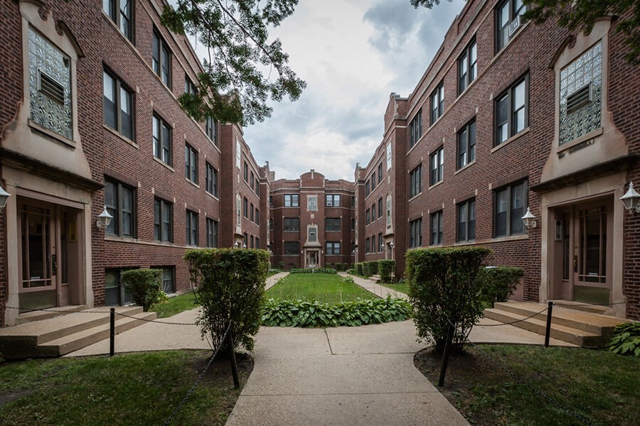 a courtyard between two brick buildings on a sunny day