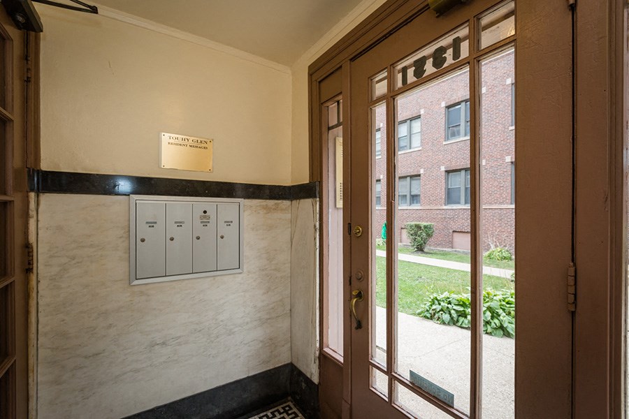 the front door of a building with a window and a sign on the wall