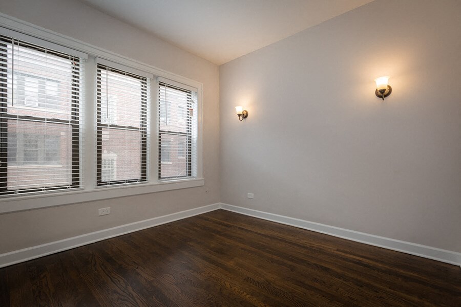 the living room of a home with wood floors and windows