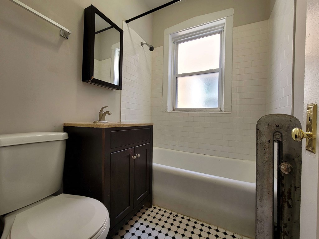 a bathroom with a toilet and a sink and a tub