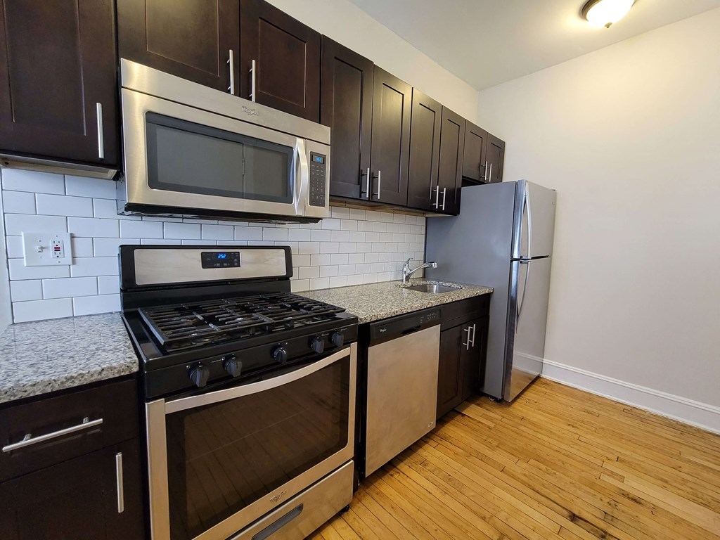 a kitchen with stainless steel appliances and black cabinets