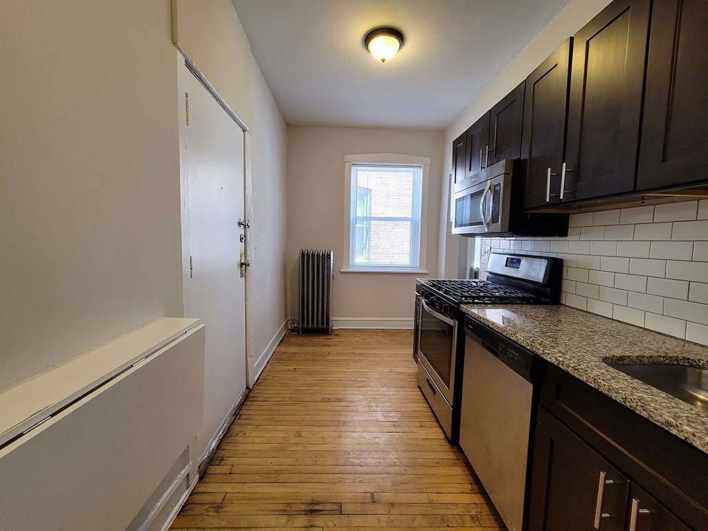 a kitchen with black cabinets and a stove and a window