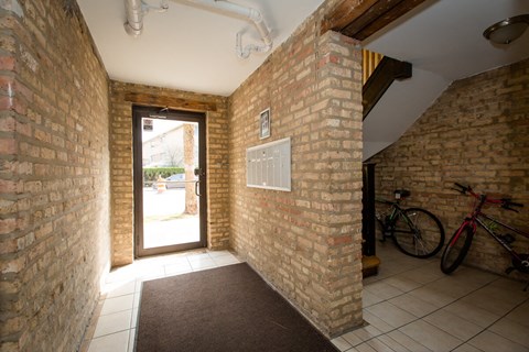 the entryway to the house has a brick wall and a door with a bike