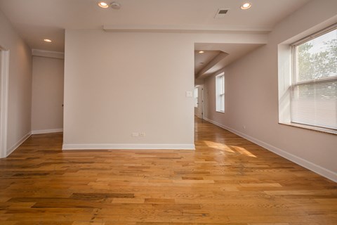 a living room and hallway with wood floors and white walls