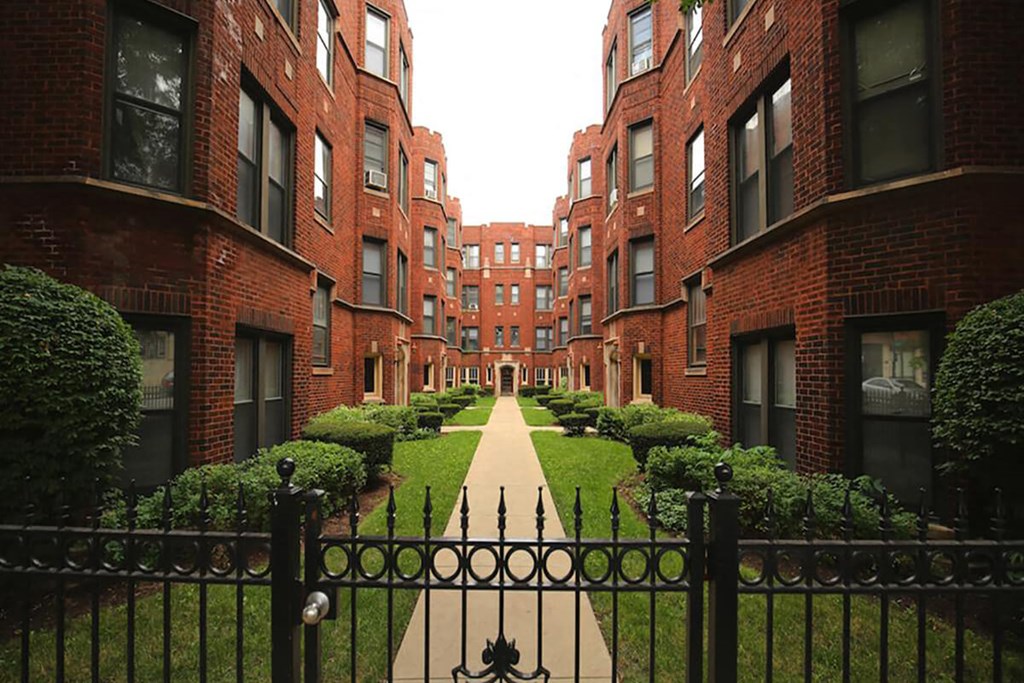 a courtyard in the middle of some red brick apartments