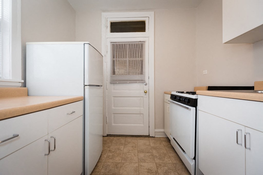 a kitchen with white appliances and a white door