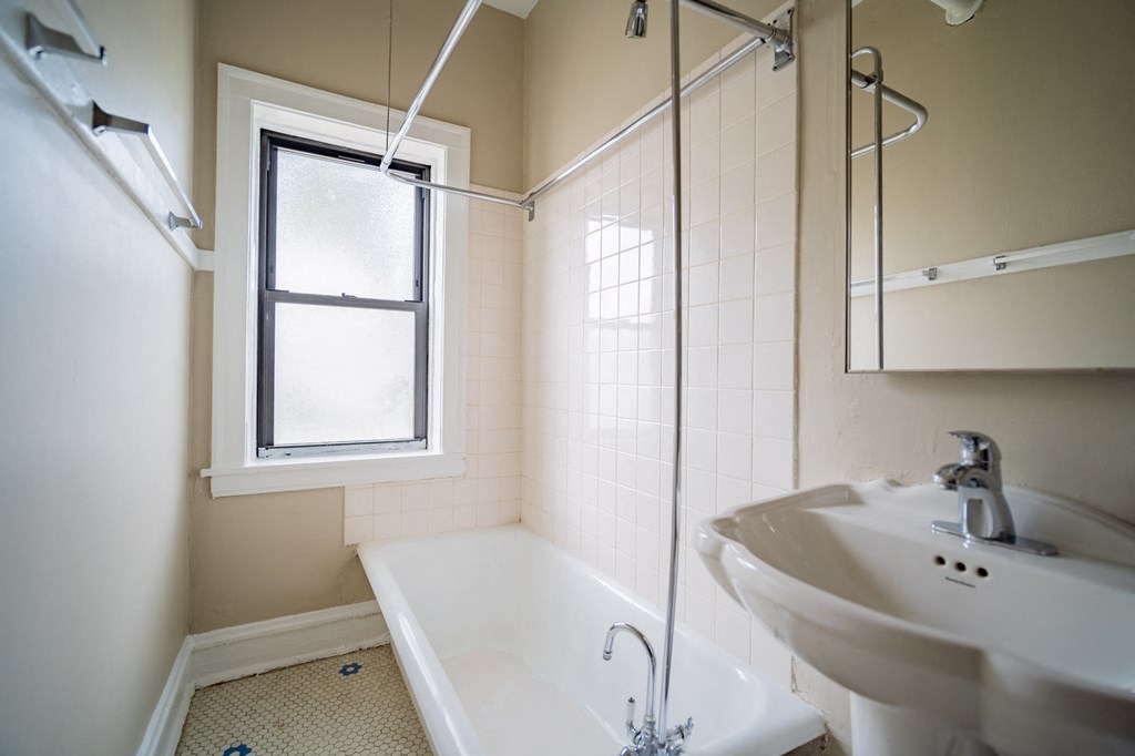 a bathroom with a tub and a sink and a window